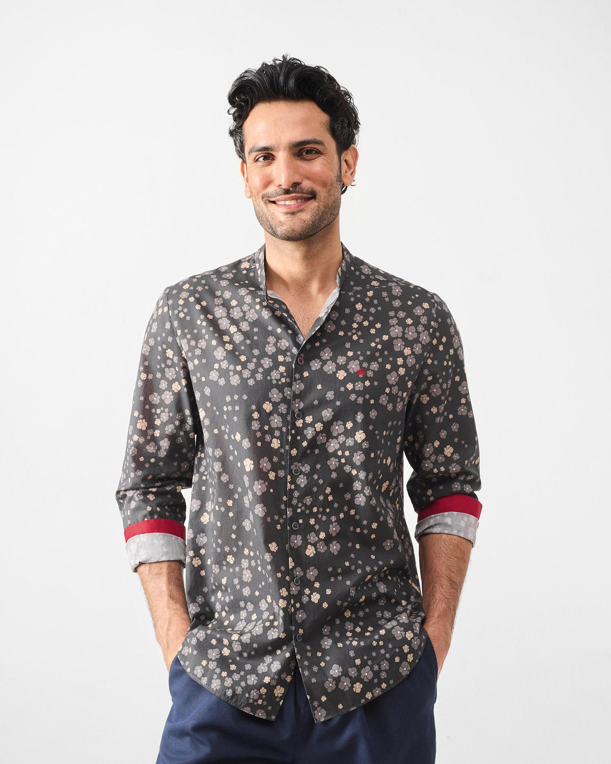 Person wearing a charcoal Nawab Shirt with a ditsy floral print and red cuff lining.