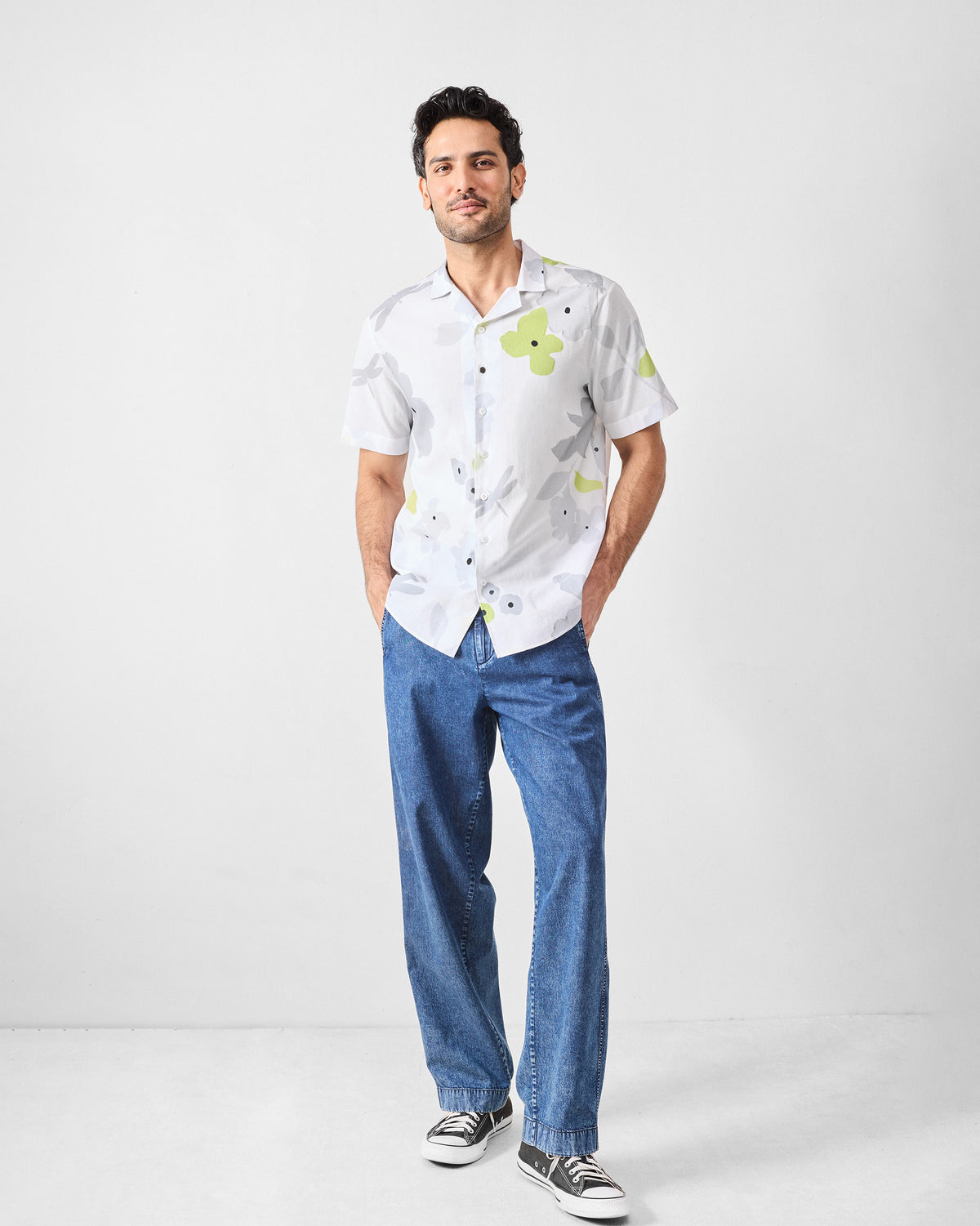 Person wearing a white Mistari Shirt with a lime and grey floral print.