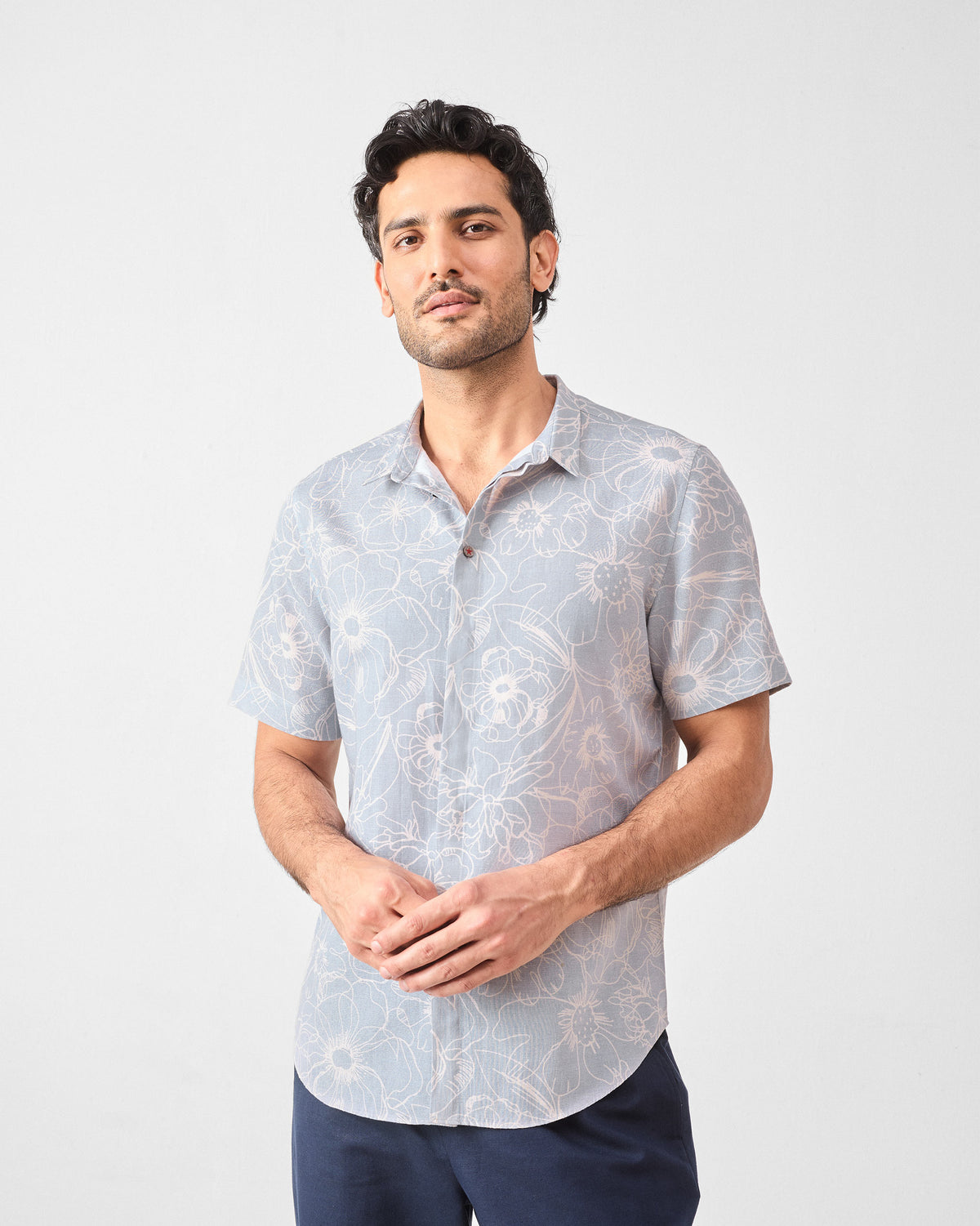 Person wearing a grey Riverline shirt with white floral print.