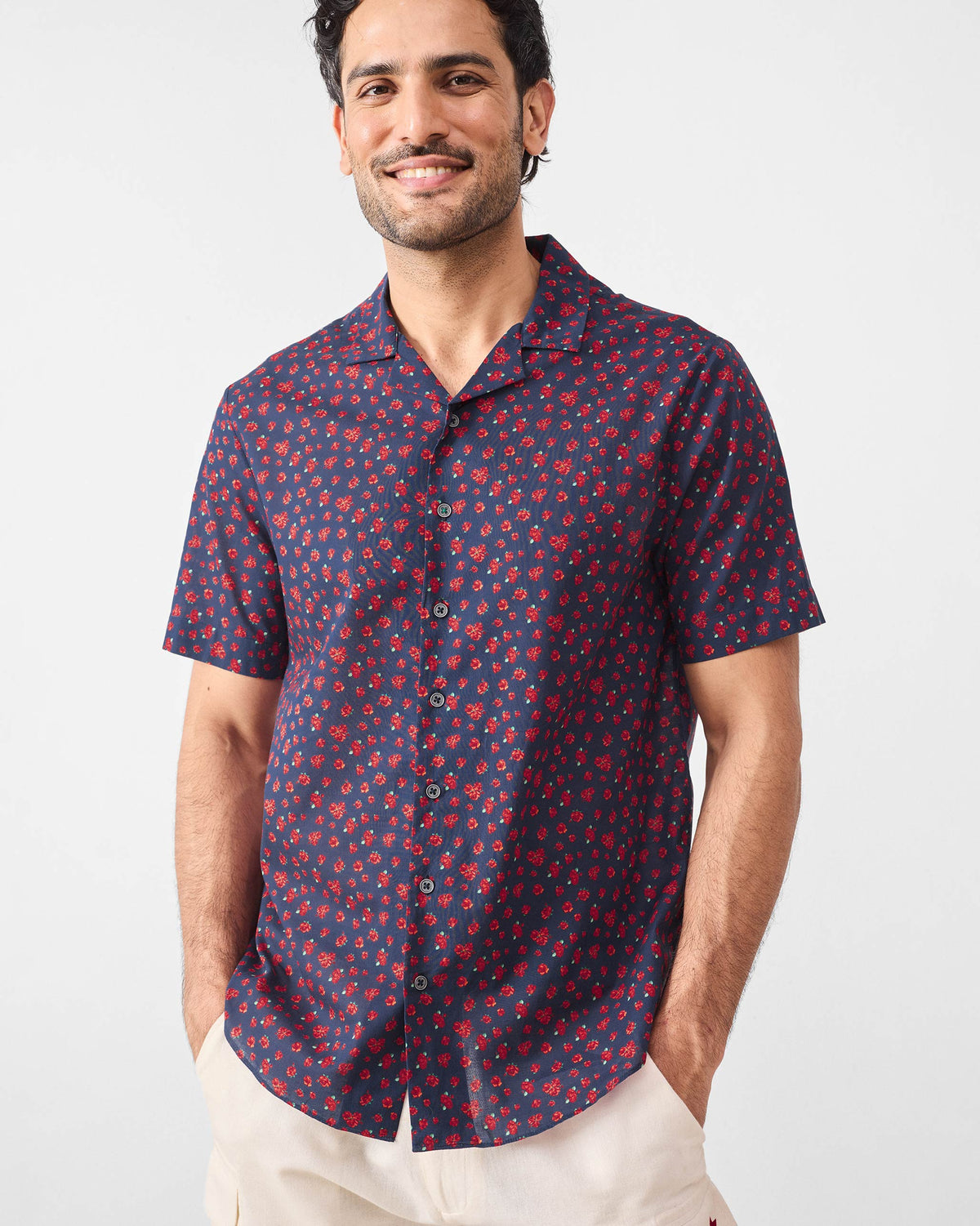 Person wearing a navy Mistari shirt with an all-over red rose print.