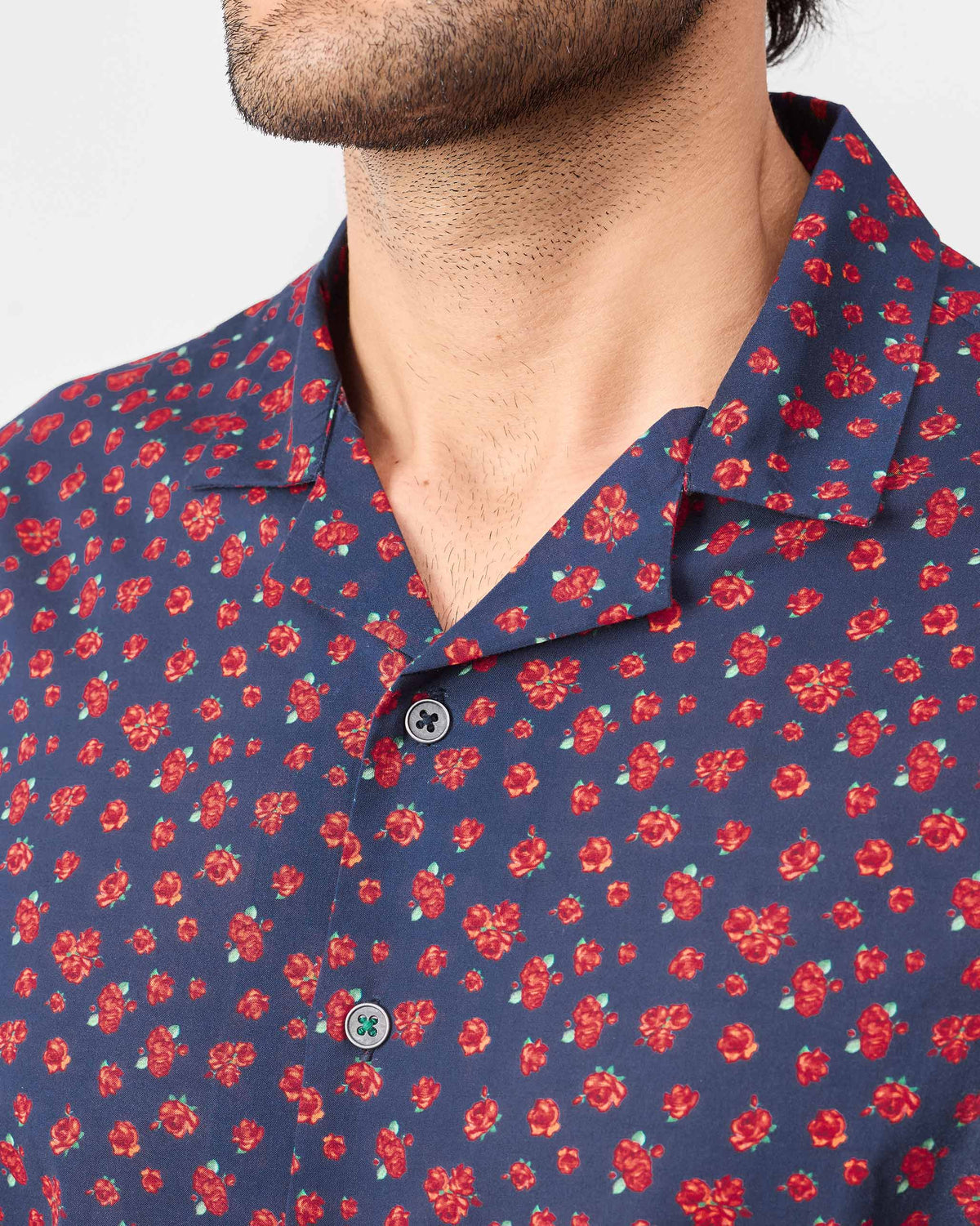 Close-up of a navy Mistari shirt showing the small red rose print.