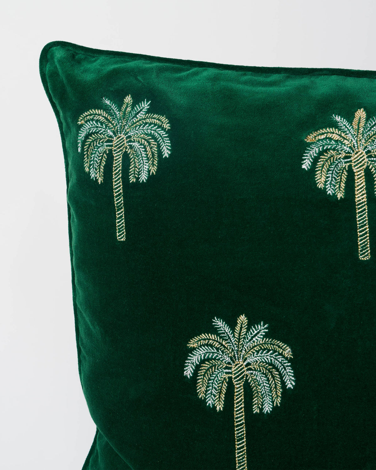 Close-up of a Palm Shimmer Cushion Cover showing embroidered palm trees in silver and gold thread.