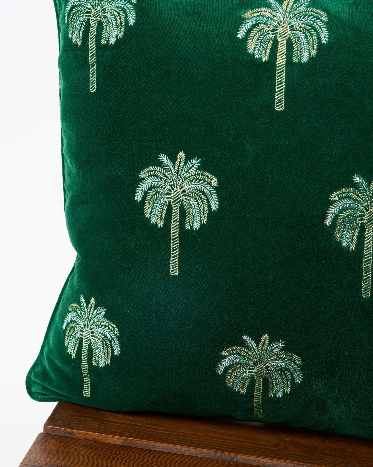 Corner of a Palm Shimmer Cushion Cover showing embroidered palm trees.