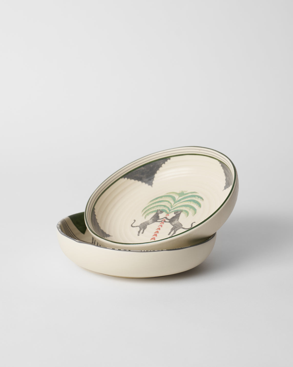 Stacked Indus Shallow Bowls with leopards and a palm tree motif.