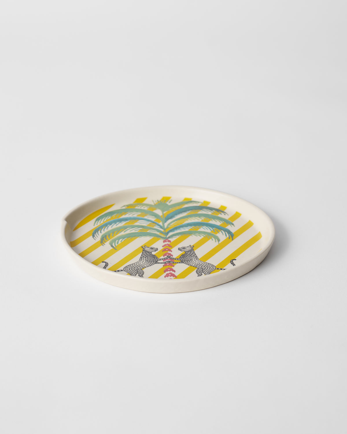 Side view of Bagh dessert plate with yellow stripes and a palm.