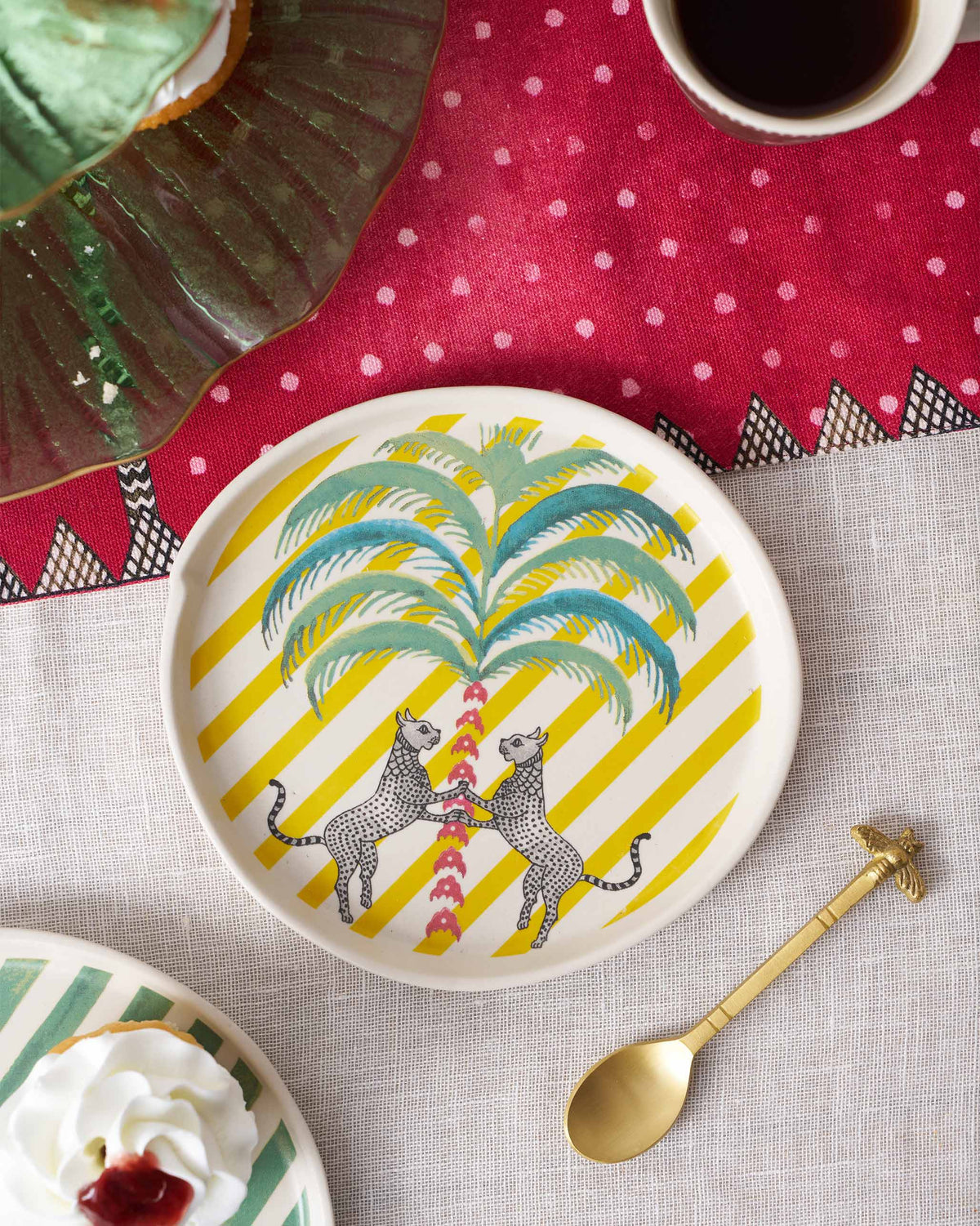 Bagh dessert plate in use with a palm and two leopards on yellow stripes.