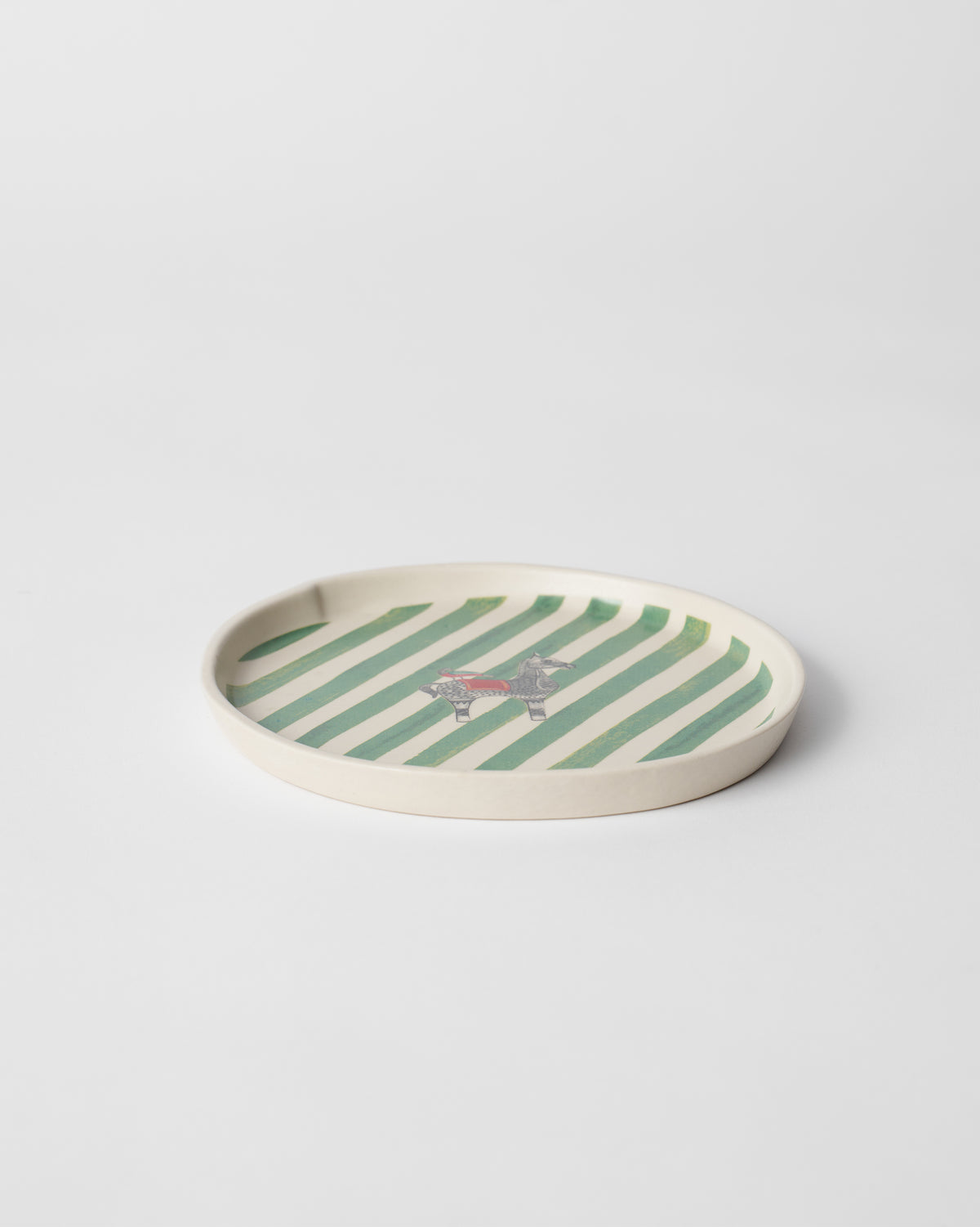 Indus Dessert Plate seen at an angle, with green stripes and a small animal.