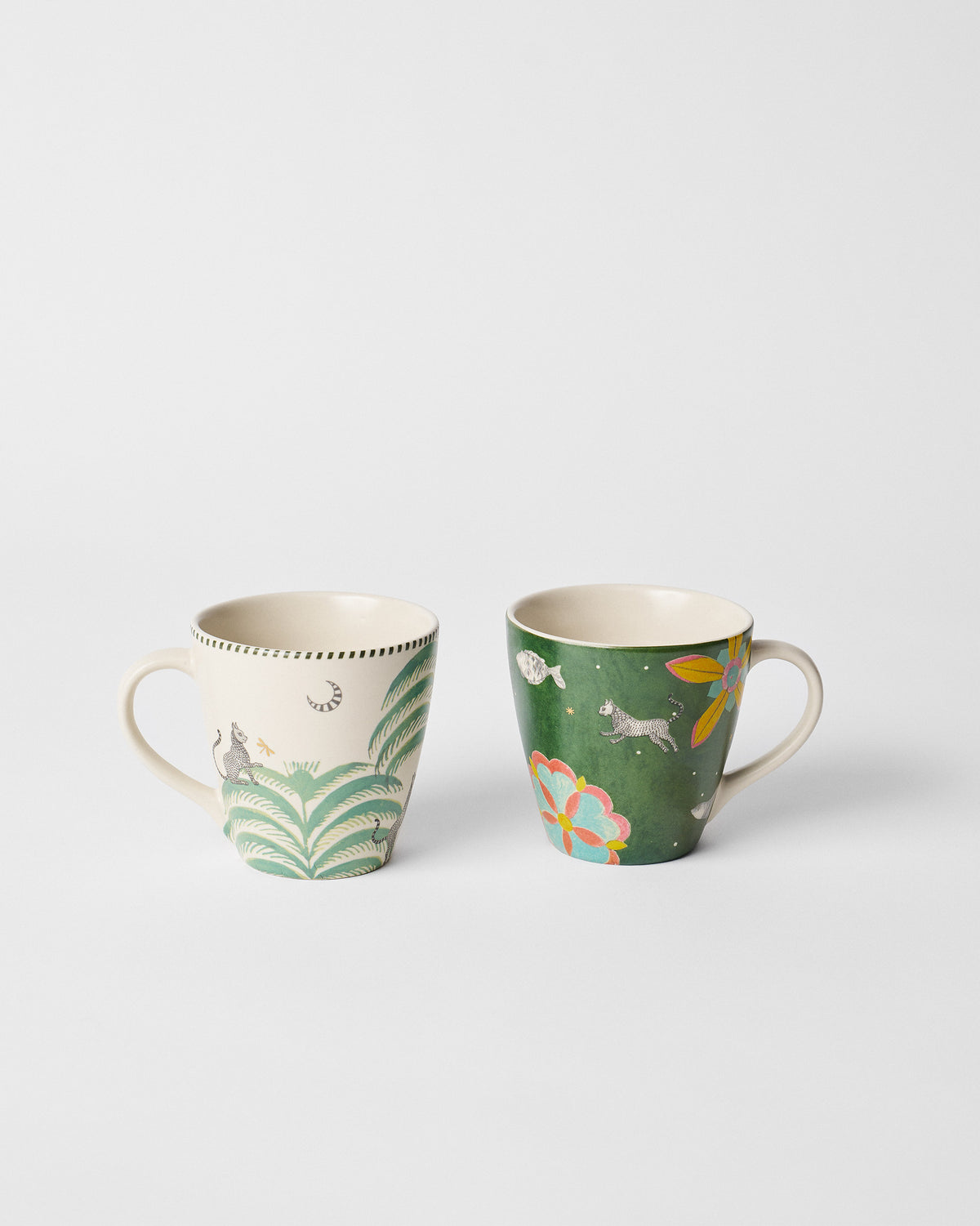 Cream and forest-green conical mugs with fauna, flora, and moon motifs.