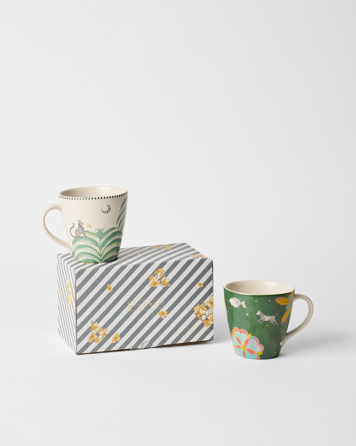 Cream and green Indus mugs shown with a striped floral Nicobar gift box.