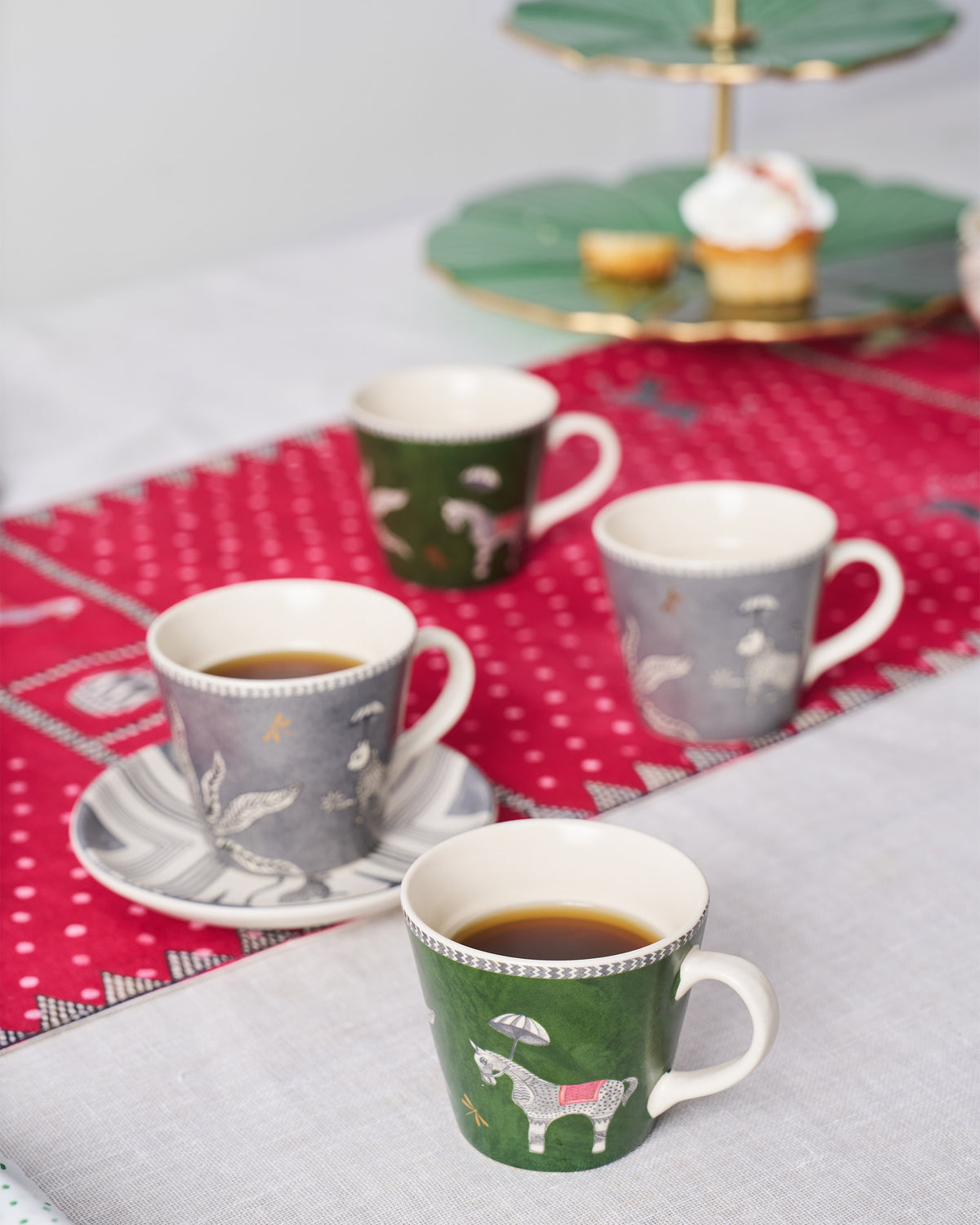 Indus espresso mugs filled with coffee on a red patterned runner.