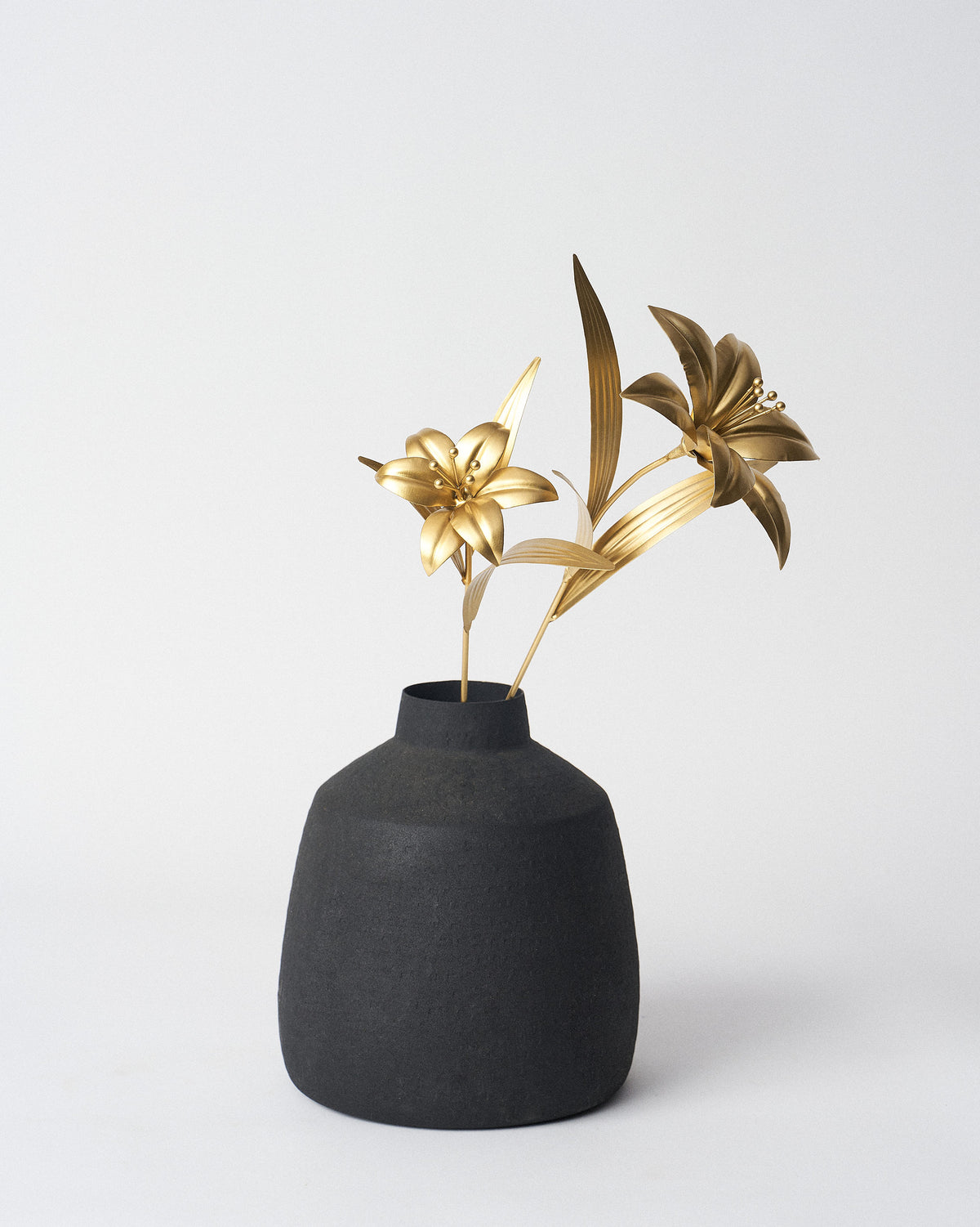 Gold Lily Accent Pieces displayed in a black vase.