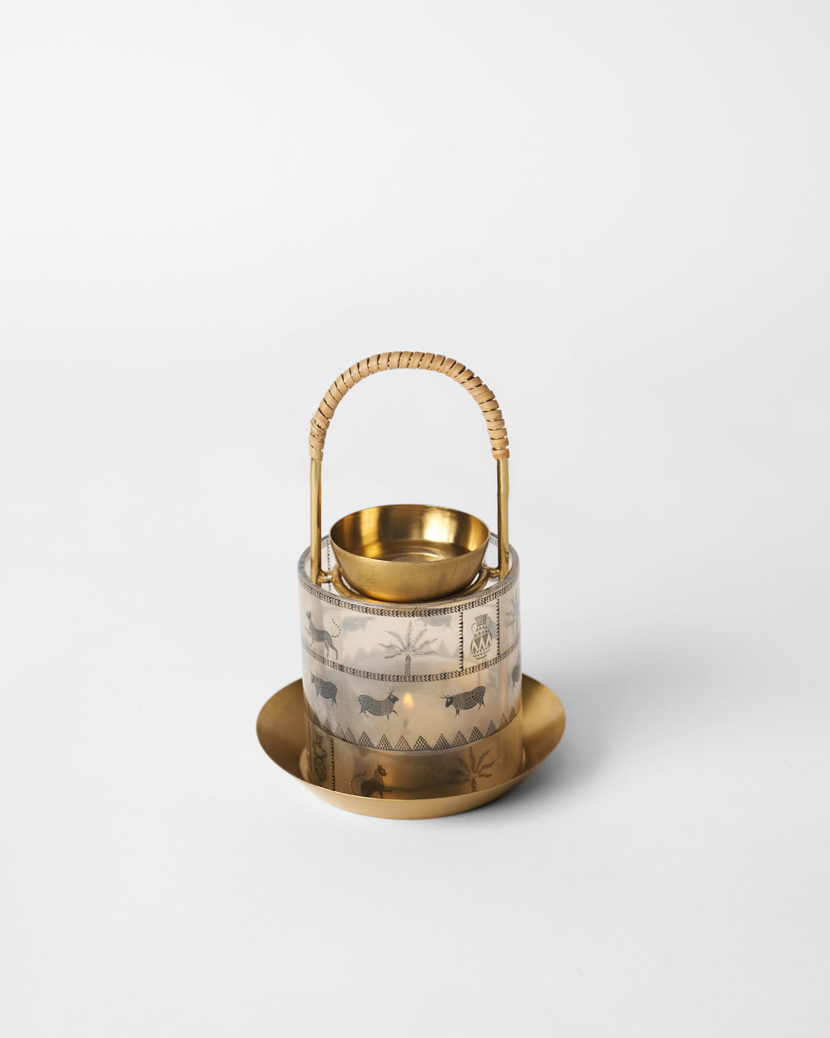 Lit Indus diffuser glowing through its animal and palm glass sleeve.