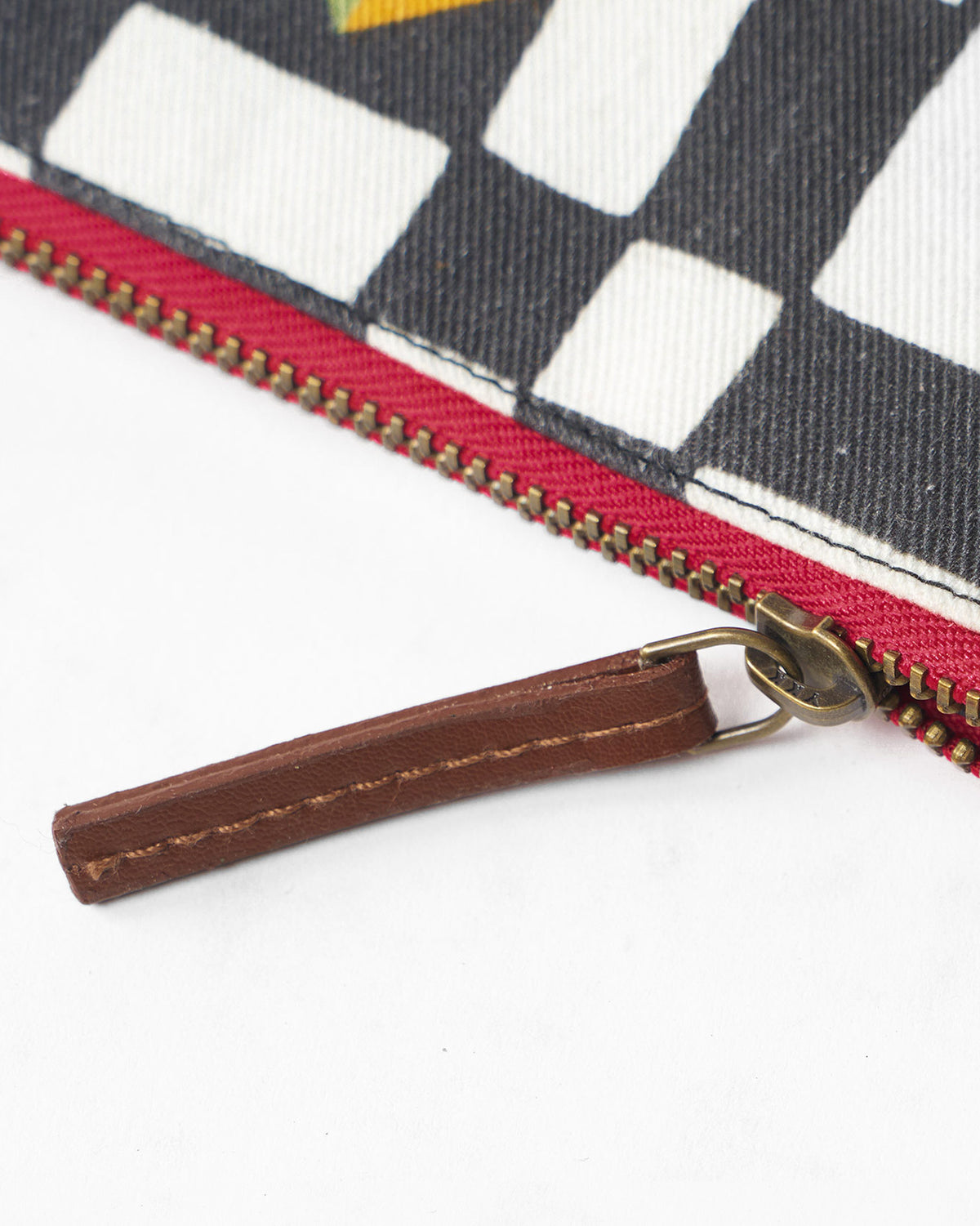 Close-up of the red zipper and leather pull on a multicolor Abstract Heart Pouch.