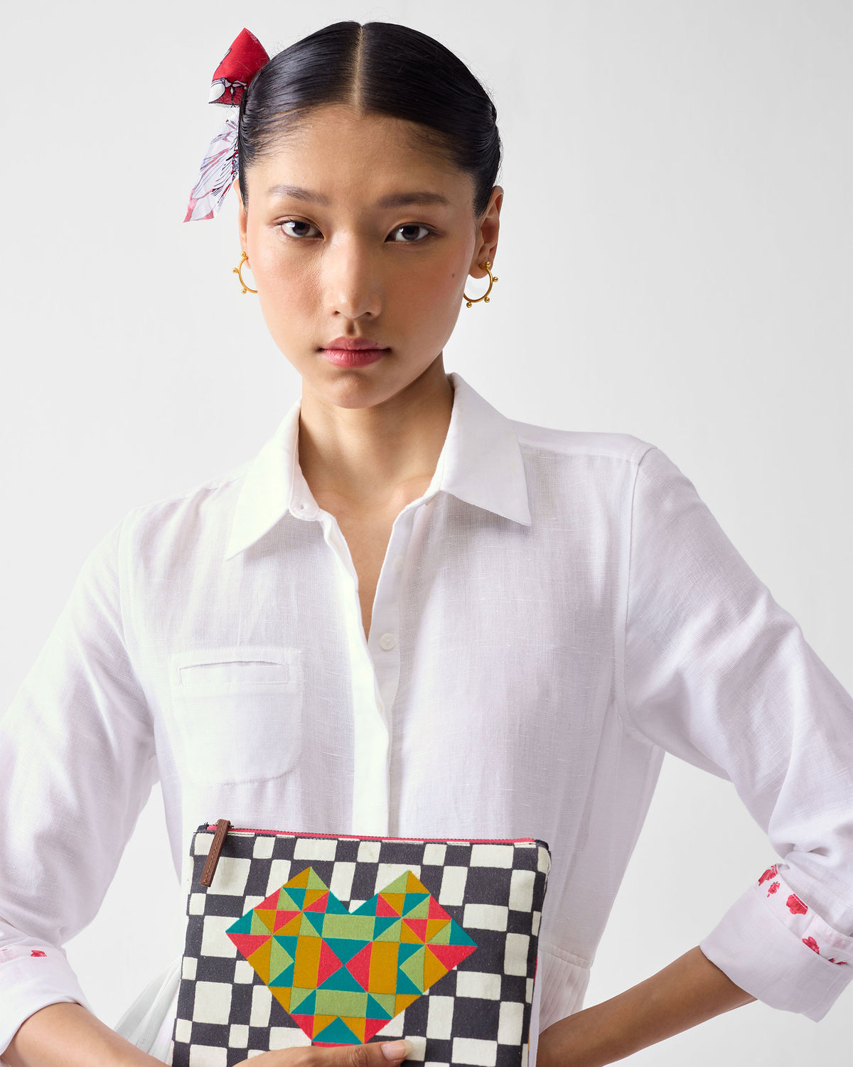Person holding a multicolor Abstract Heart Pouch with a geometric heart print.