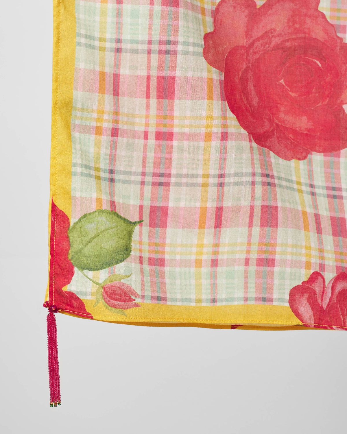 Close-up of Ruhm scarf corner showing a red rose, leaf and yellow border.
