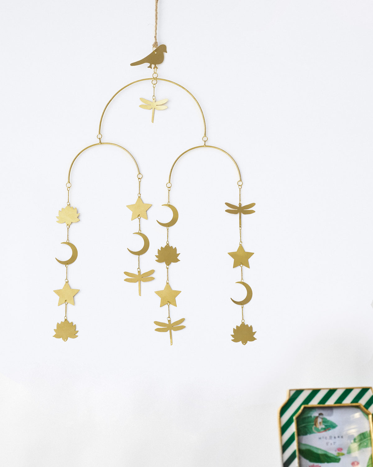 Gold Lotus toran hanging on a wall with celestial and lotus charms.