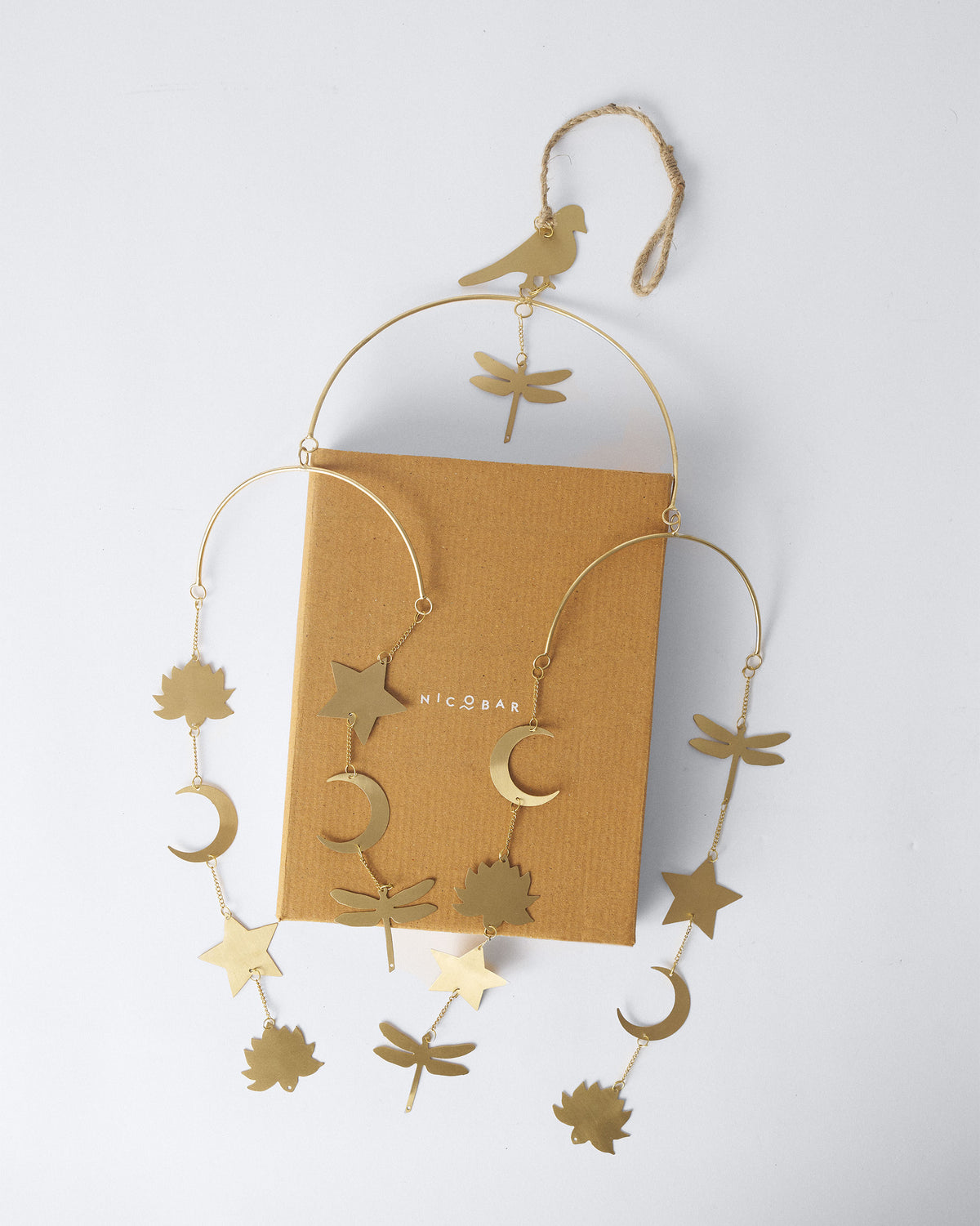 Gold Lotus toran draped over a mustard Nicobar gift box.