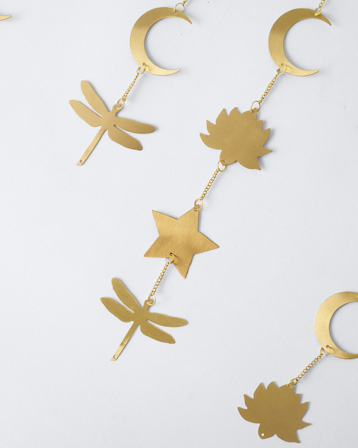 Close-up of Lotus toran charms: lotus, star, moon and dragonfly.