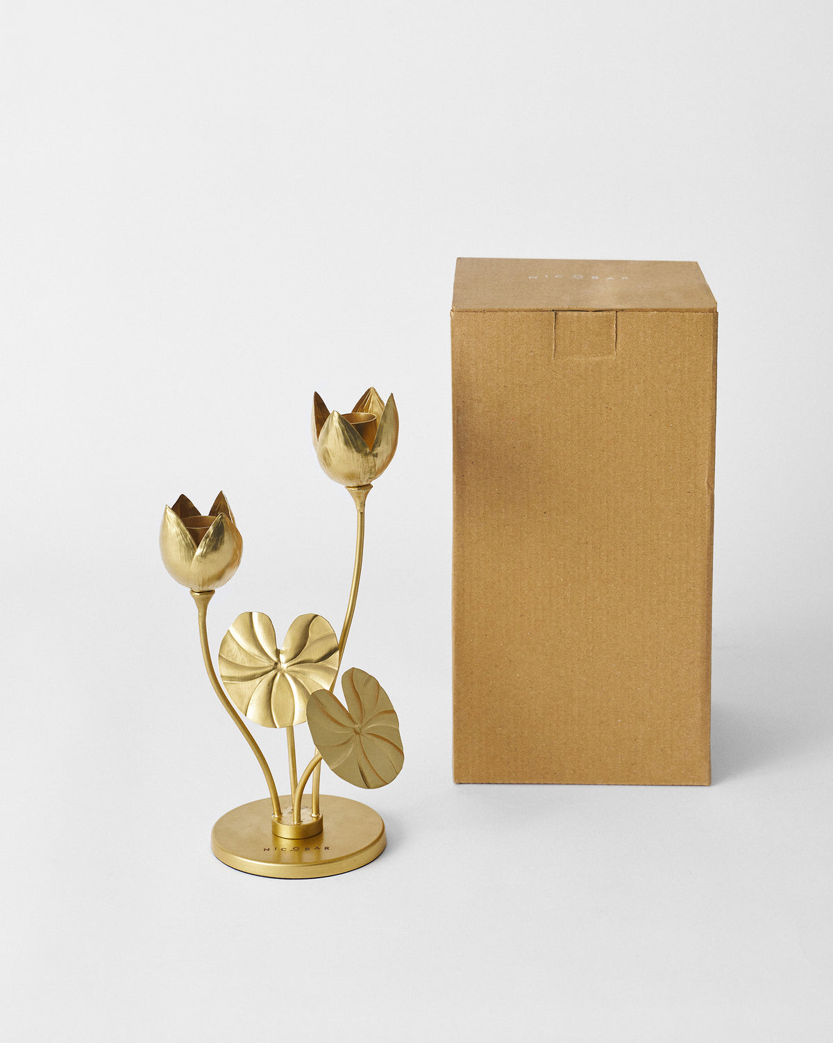 Island Lotus candle holder beside its tall kraft gift box.