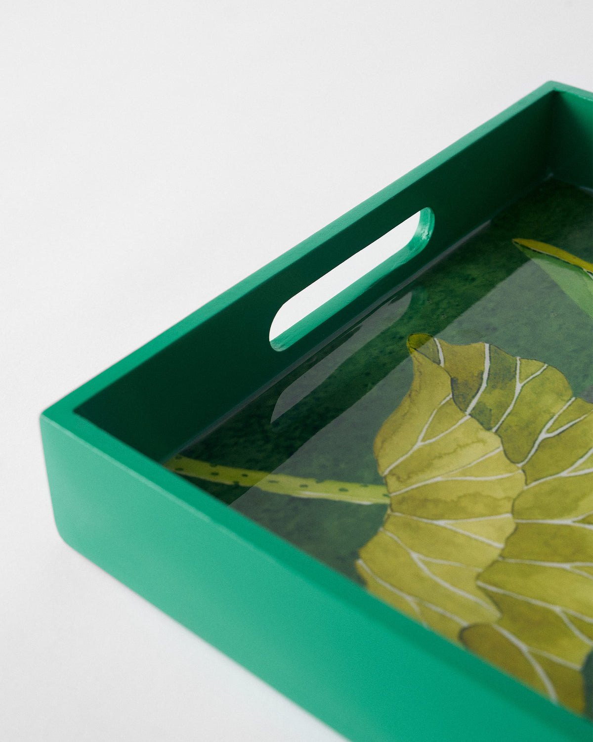 Close-up of Lotus tray corner showing emerald rim and cutout handle.