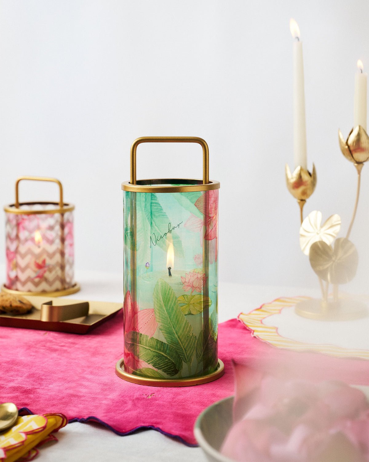 Lotus Pond lantern with a brass handle and a lit candle inside.