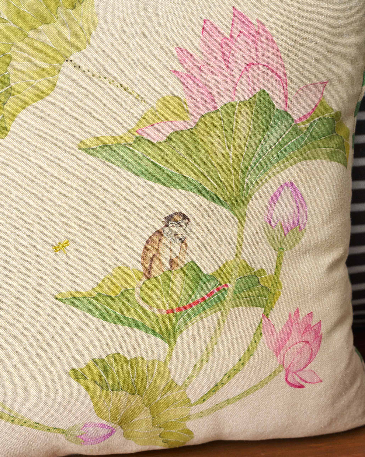 Close-up of Lotus cushion print with pink lotuses and a perched monkey.