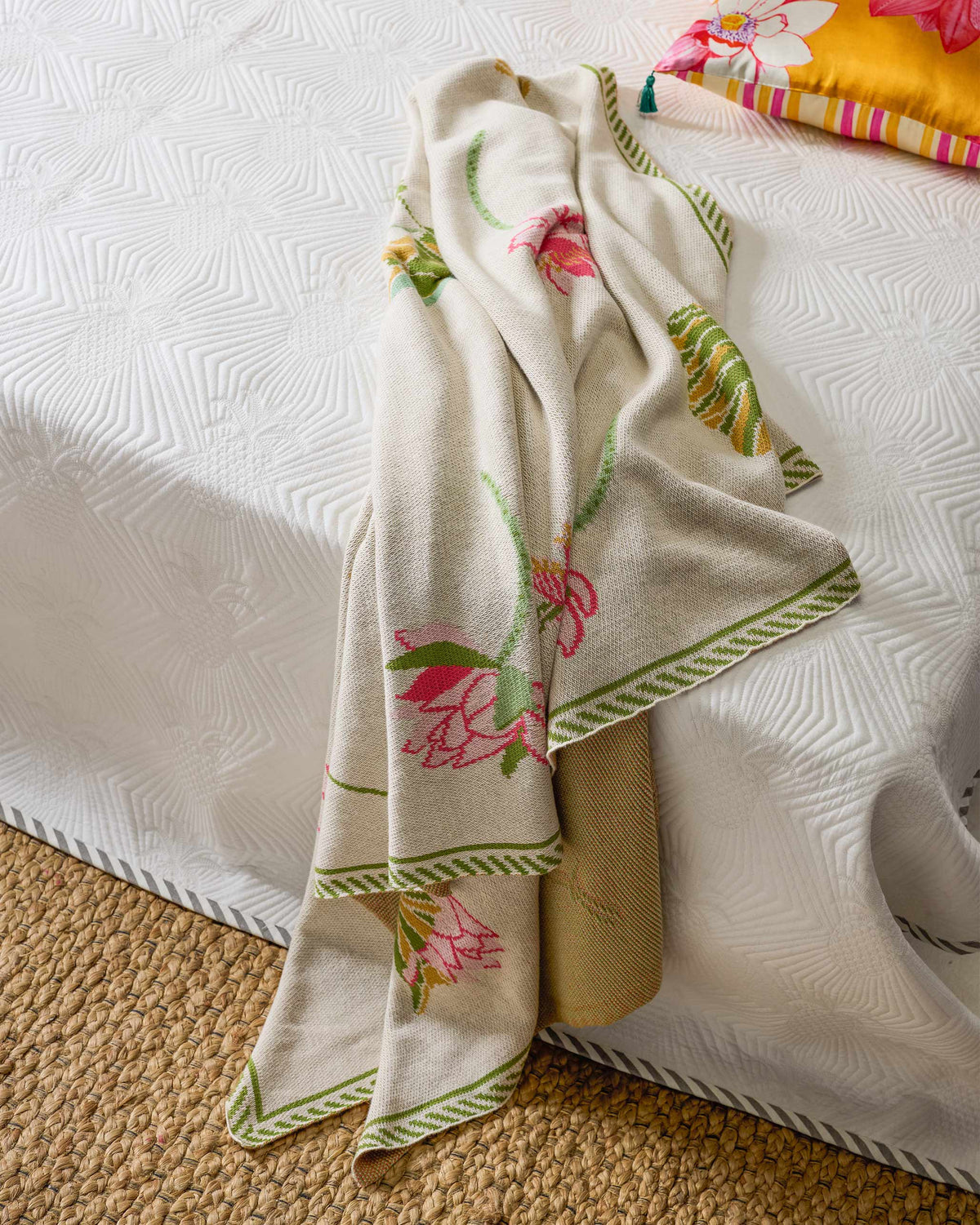 Lily Pond throw draped down one side, with pink lotus flowers and a green border.