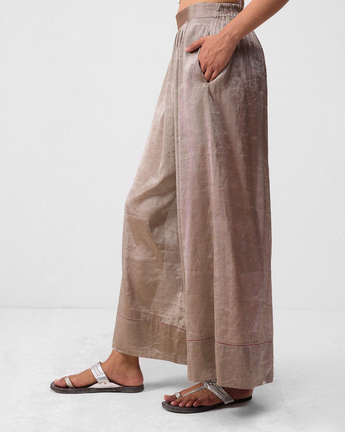 Side view of silver metallic Charisma pants with a side pocket.
