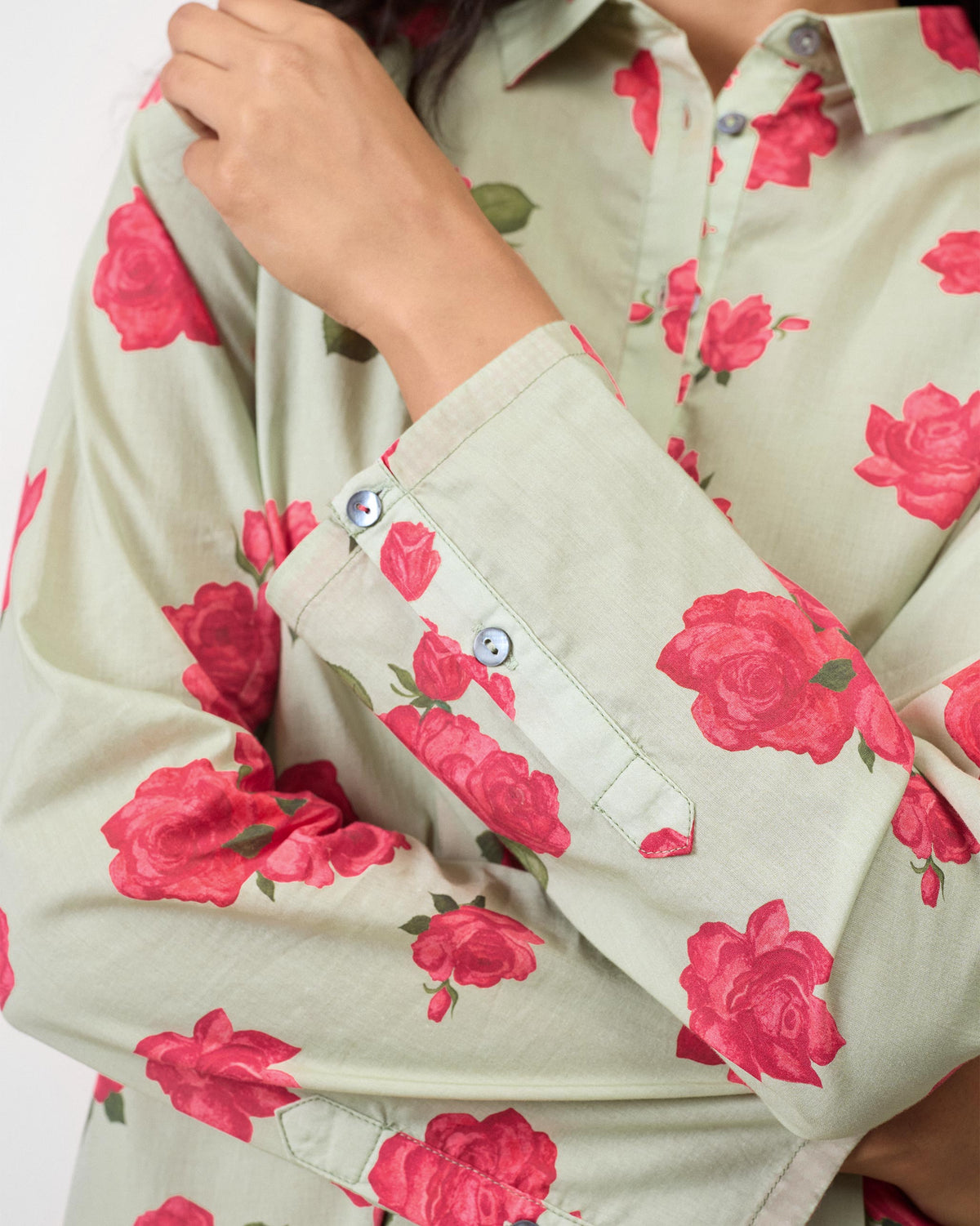 Close-up of a mint High Low Shirt showing rose print and a buttoned cuff.