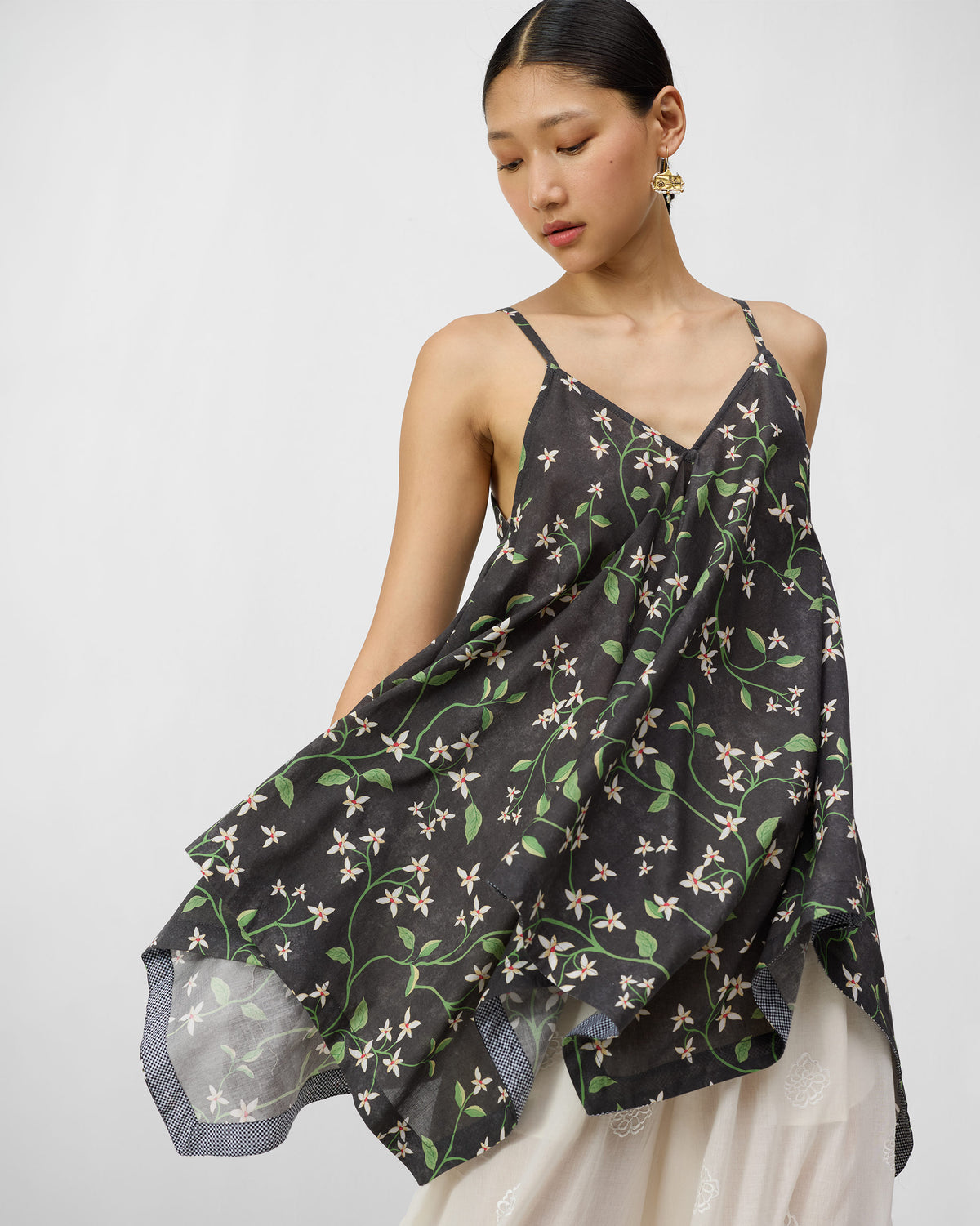 Person wearing a charcoal Handkerchief Top with an ivory jasmine print.