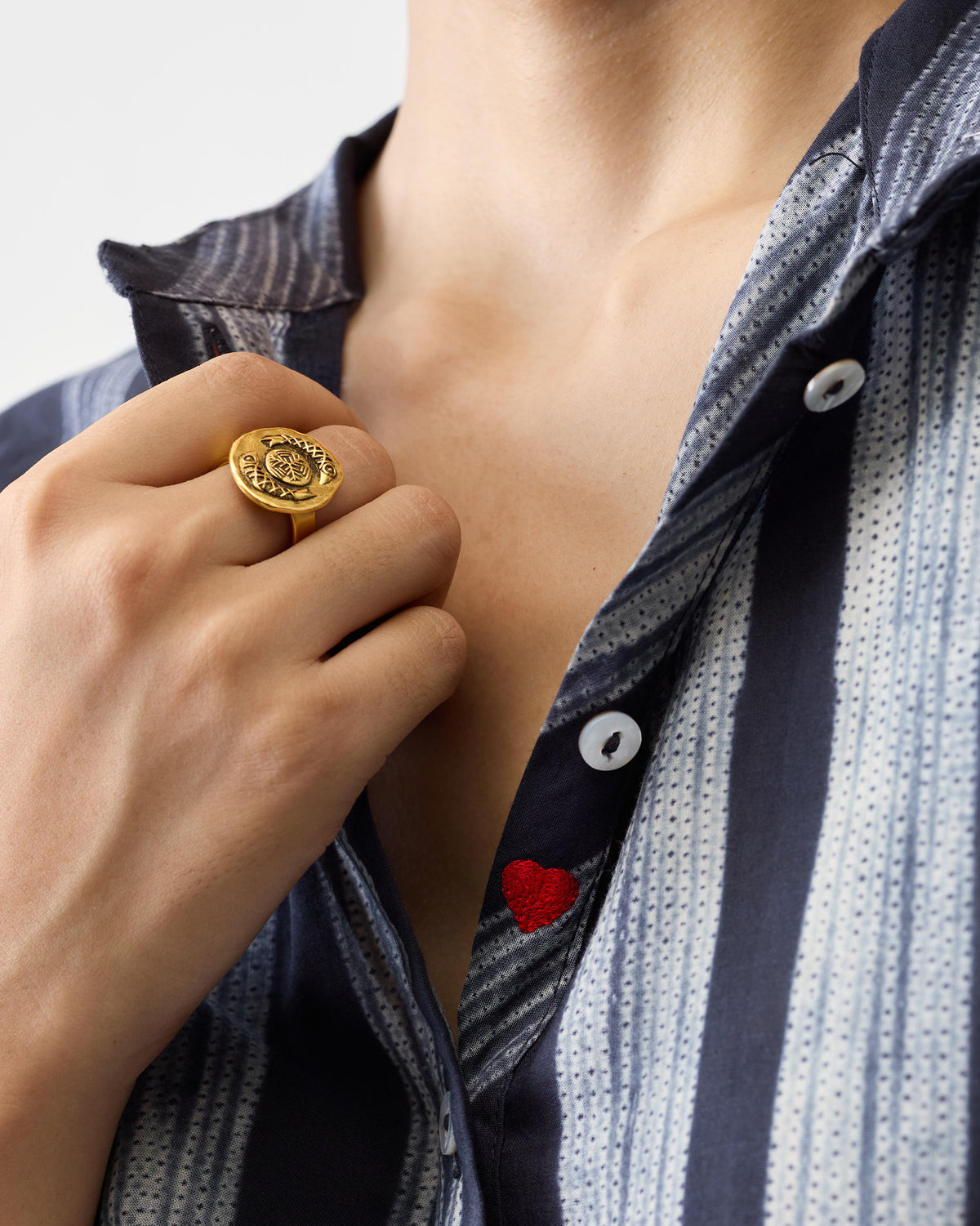 Close-up of a charcoal and ivory striped mandarin collar top showing a red heart.