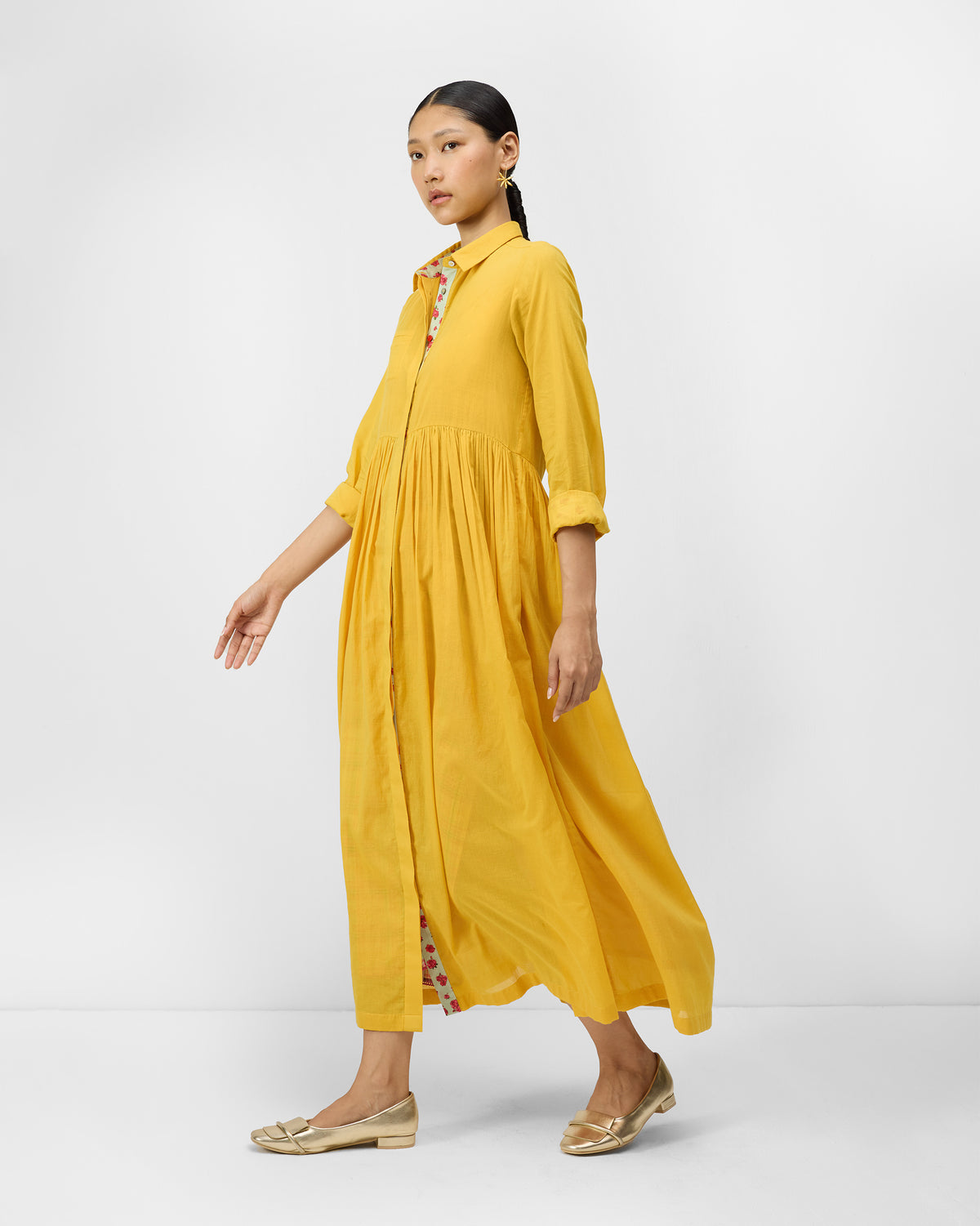 Aurora Dress three-quarter view in turmeric yellow with floral placket trim.