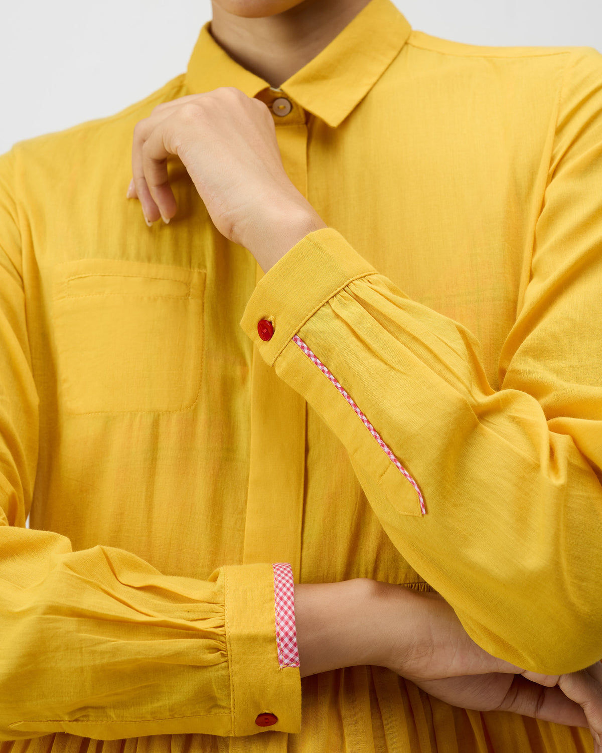 Aurora Dress bodice in turmeric yellow with check cuff trim and red buttons.