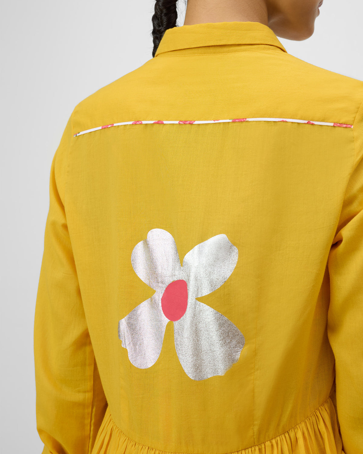 Close-up of Aurora Dress back with a silver flower and pink center.