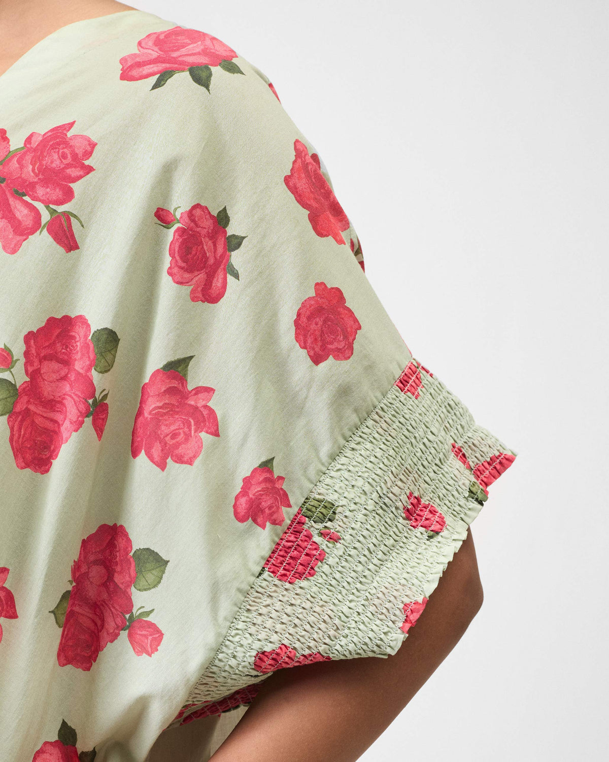 Close-up of a mint Calicut kurta sleeve with smocked cuff and rose print.