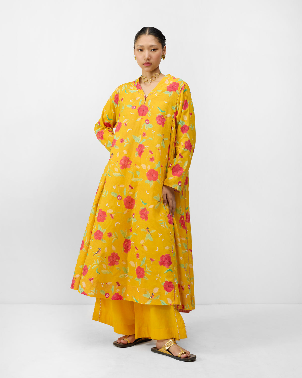 Person wearing a turmeric yellow Amreli kurta with watermelon peony print.