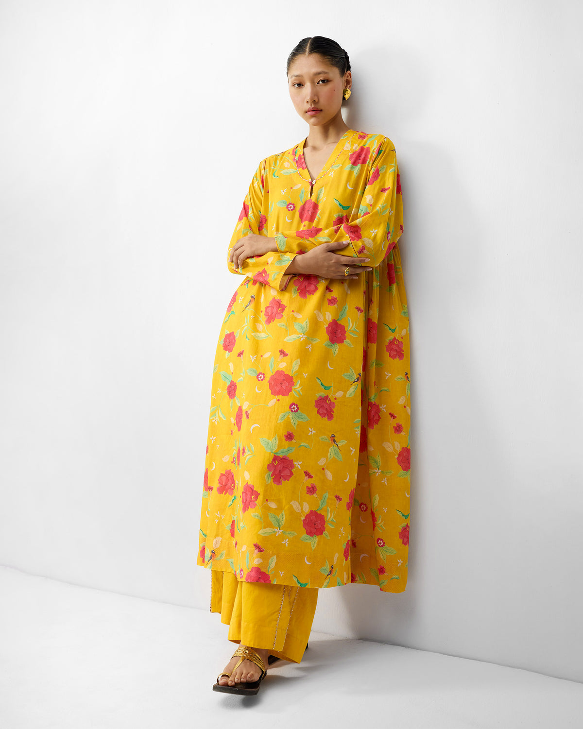Person wearing a turmeric yellow Amreli kurta with watermelon peony print.