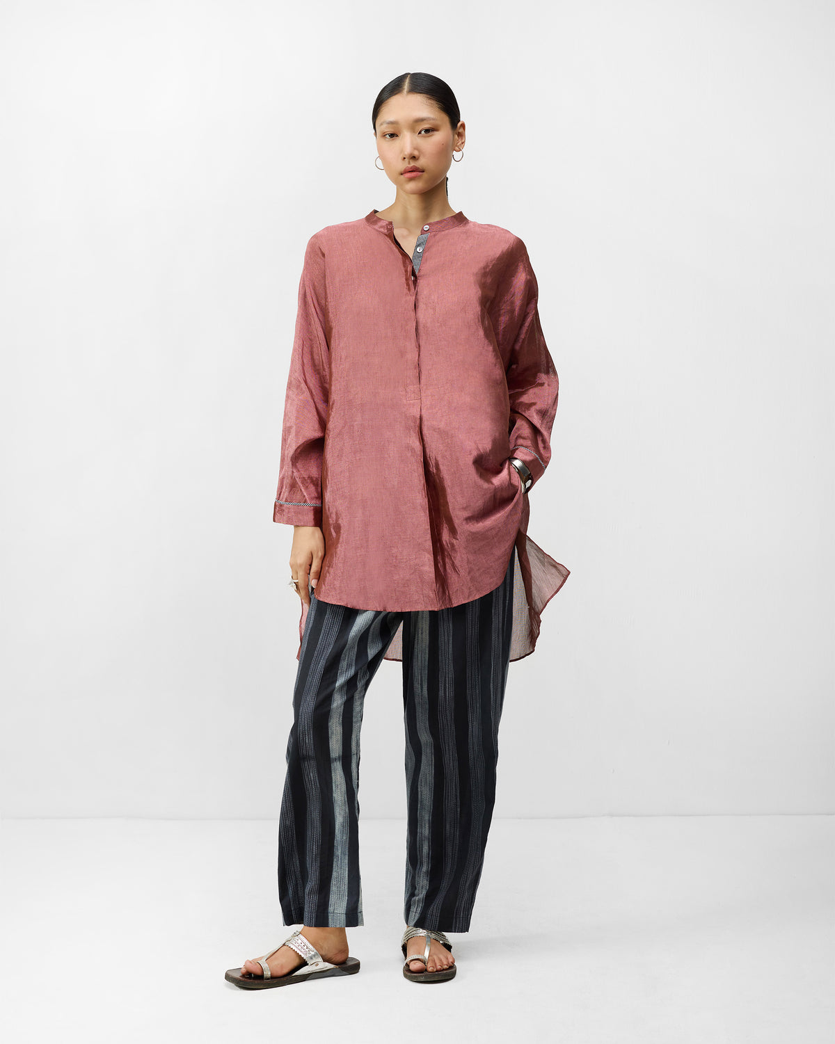 Charcoal and ivory striped Areca Pants worn full length with a pink tunic.