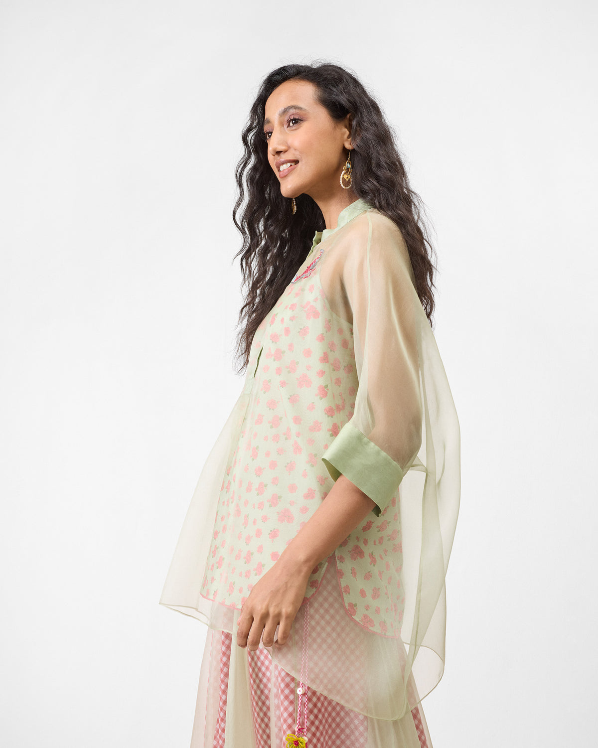 Side view of a sheer mint Jaisalmer shirt layered over a floral slip.