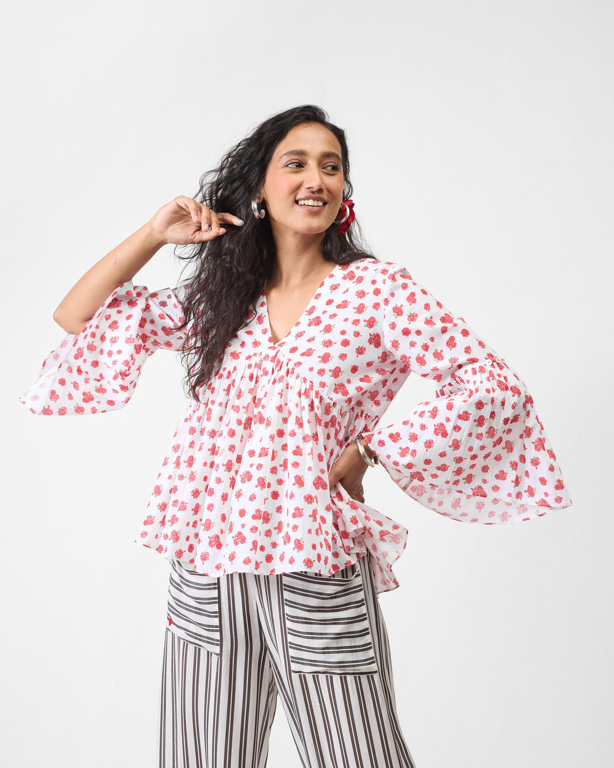 Person wearing a white watermelon print ruffle top.