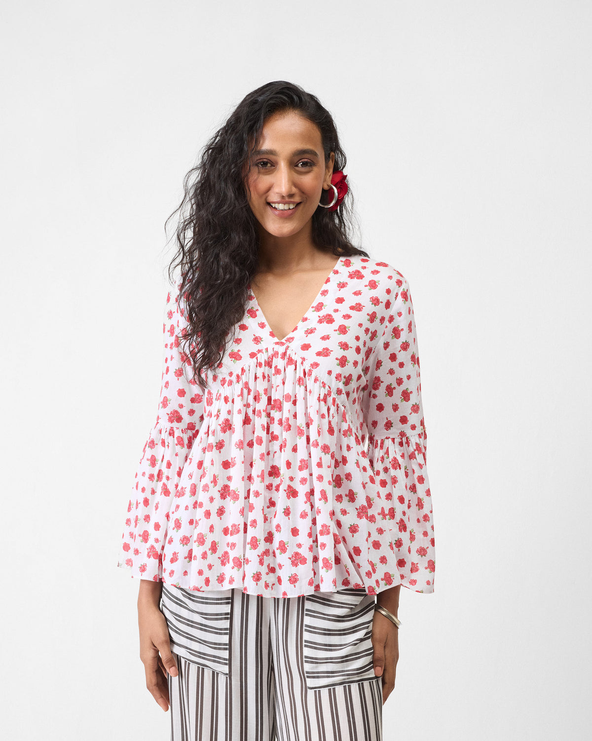 Person wearing a flared white watermelon print ruffle top.