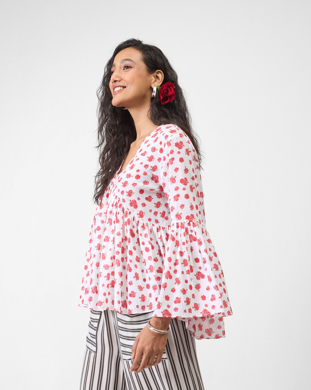 Side view of a white watermelon print ruffle top.