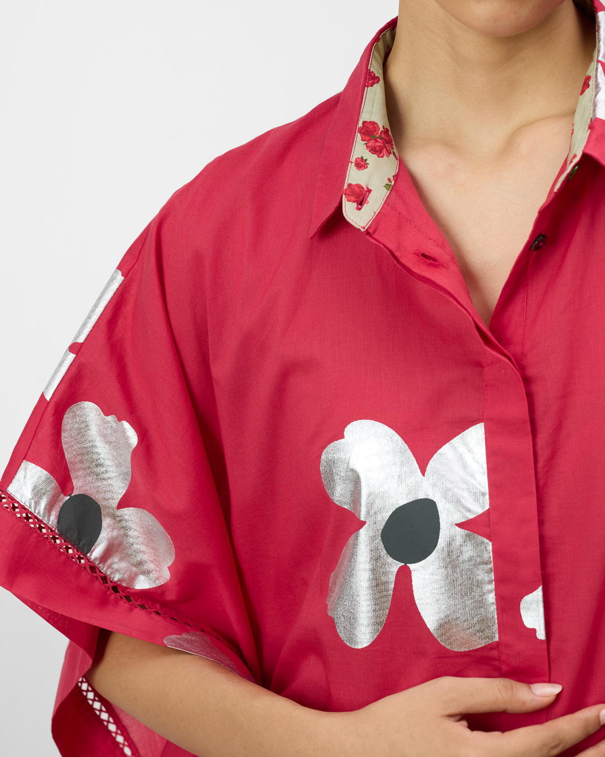 Close-up of a watermelon pink top with silver foil flowers and rose collar lining.