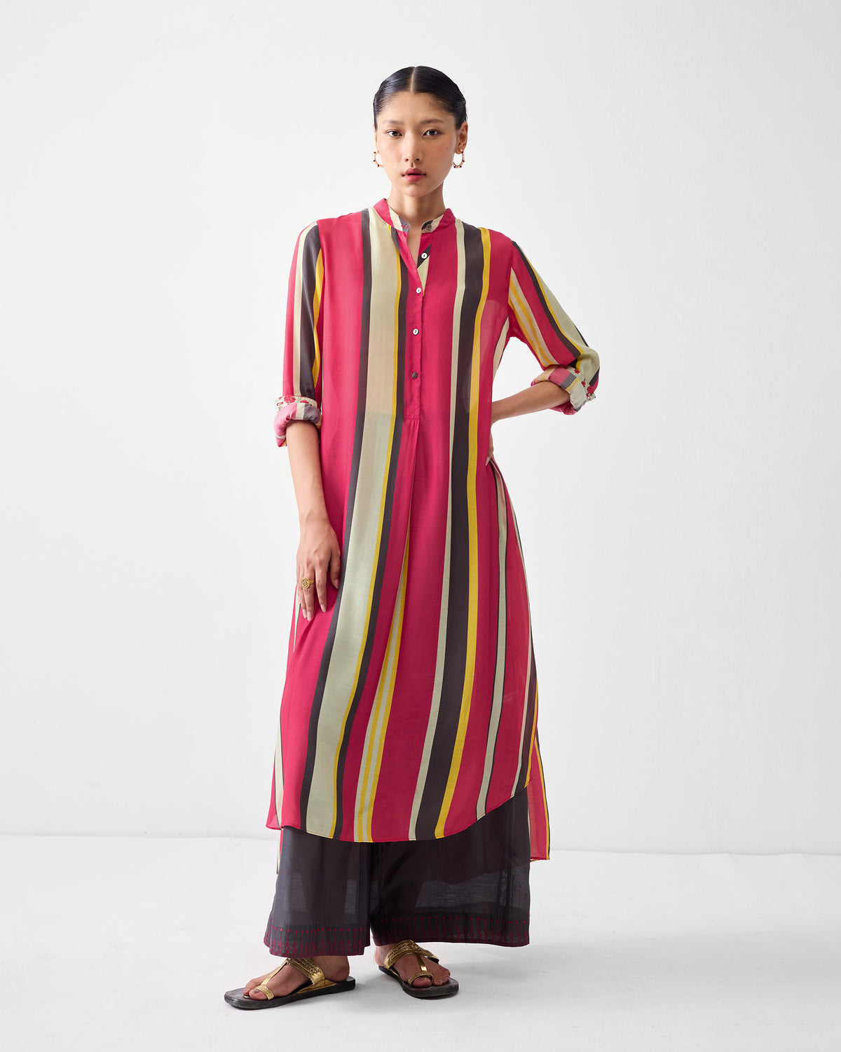 Person wearing a long multicolor striped smocked back kurta.