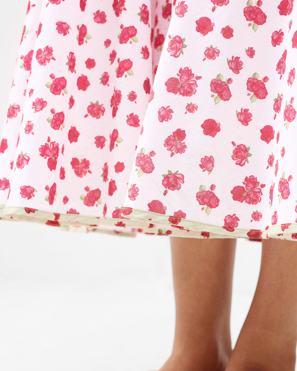 Close-up of a white Kimsuka Dress showing watermelon florals at the hem.