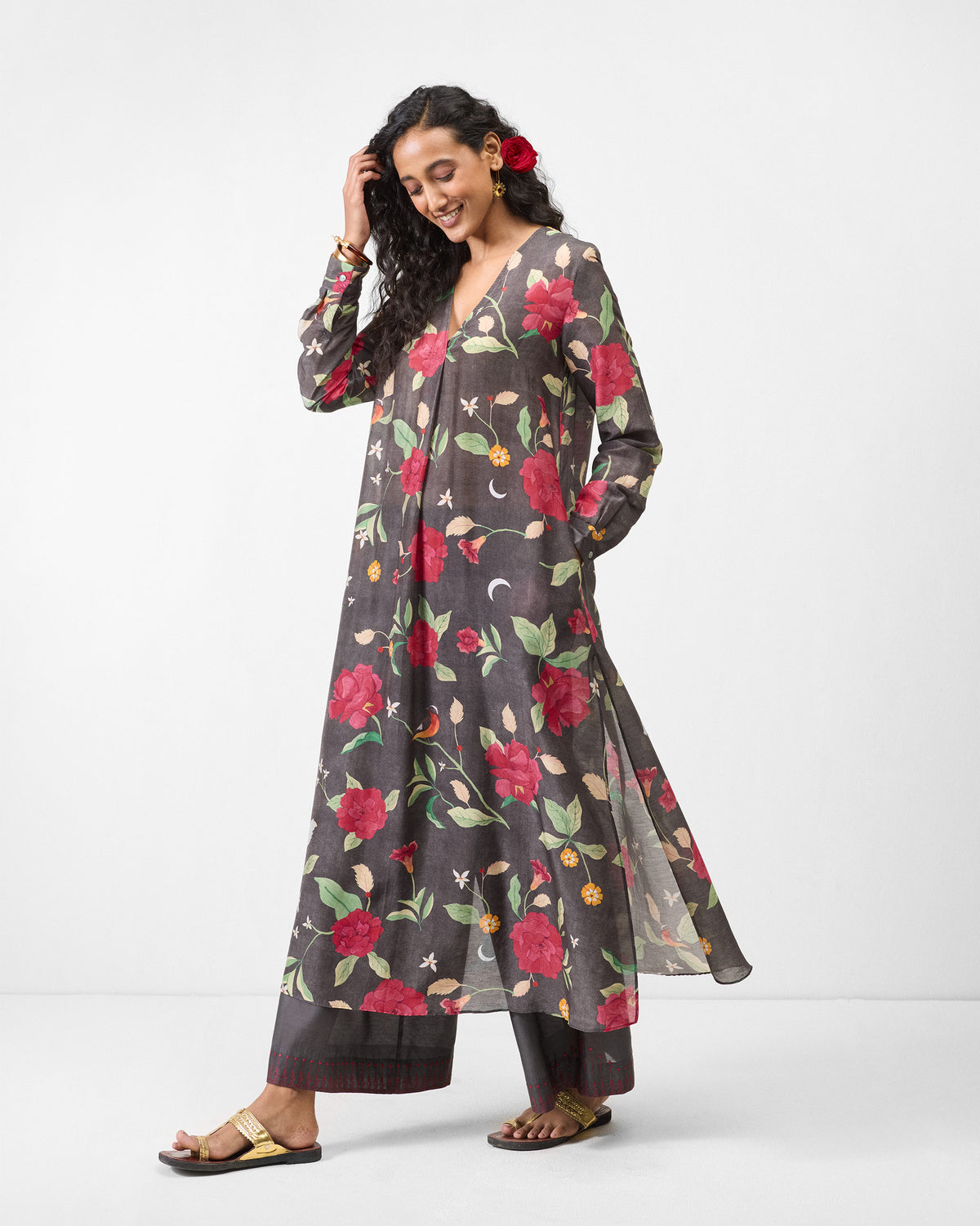 Person wearing a long charcoal kurta with red floral print.
