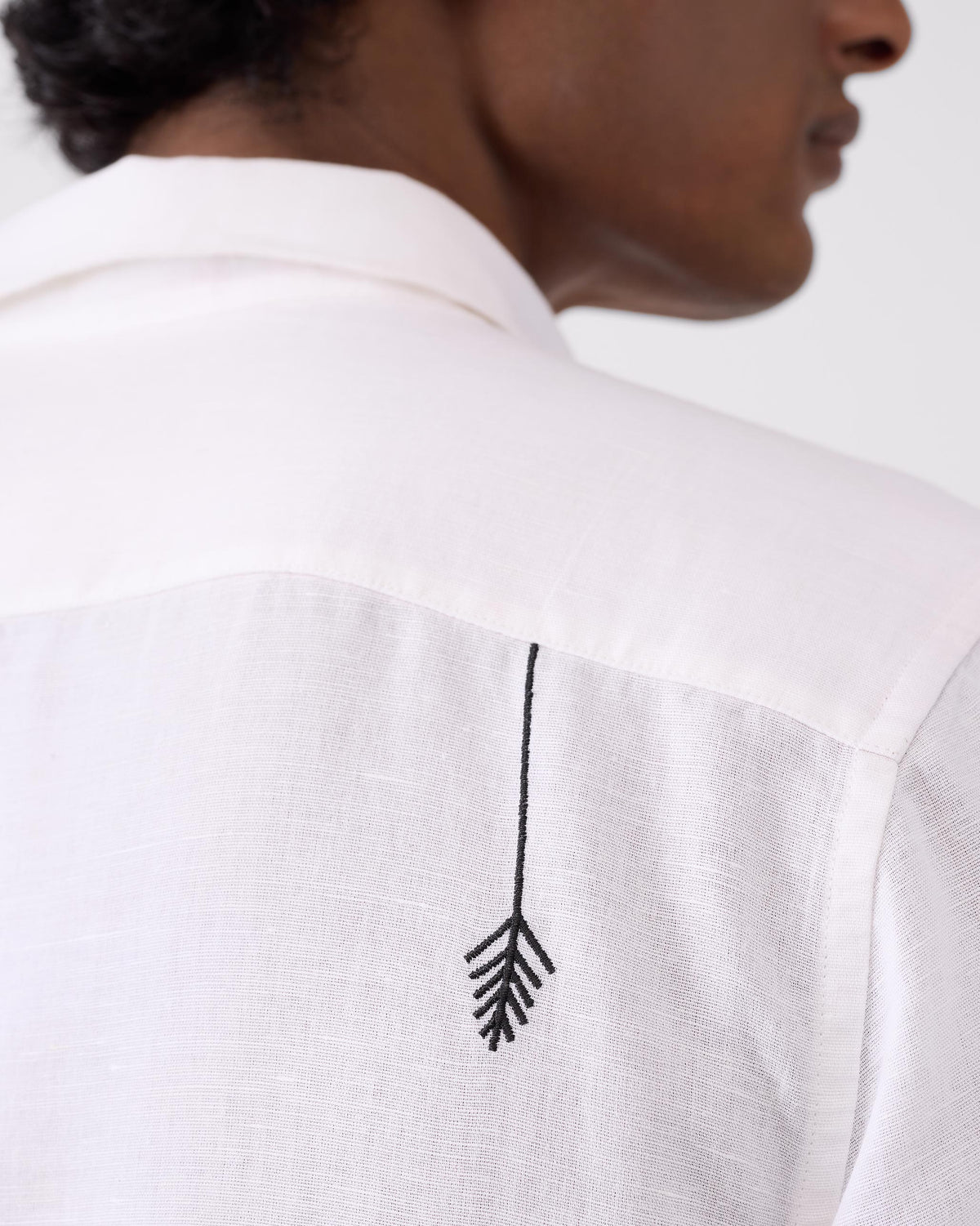 Close-up of a black plant motif on the back of a white Musafir Pocket Shirt.