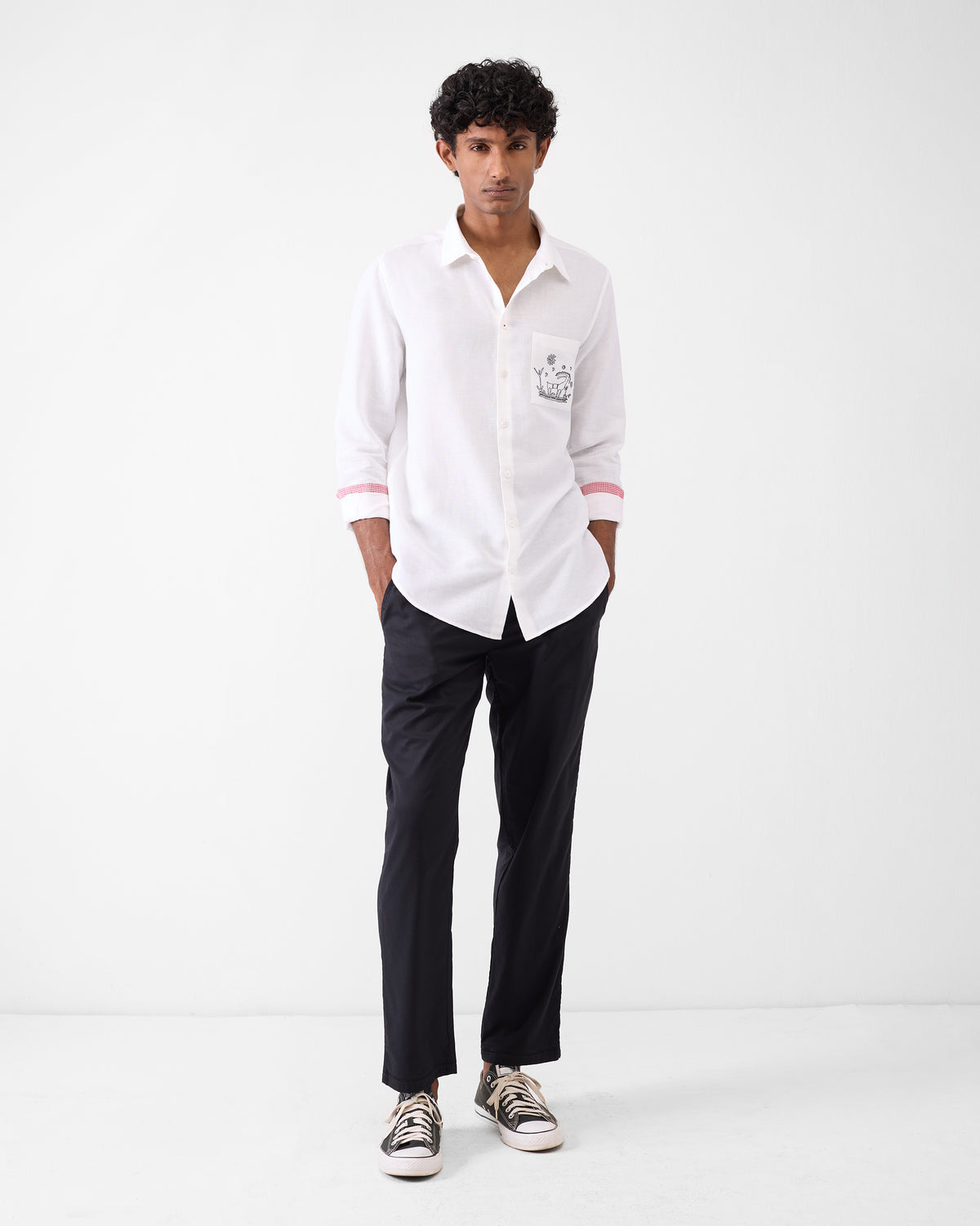 Person wearing a white Musafir Pocket Shirt with pocket embroidery.