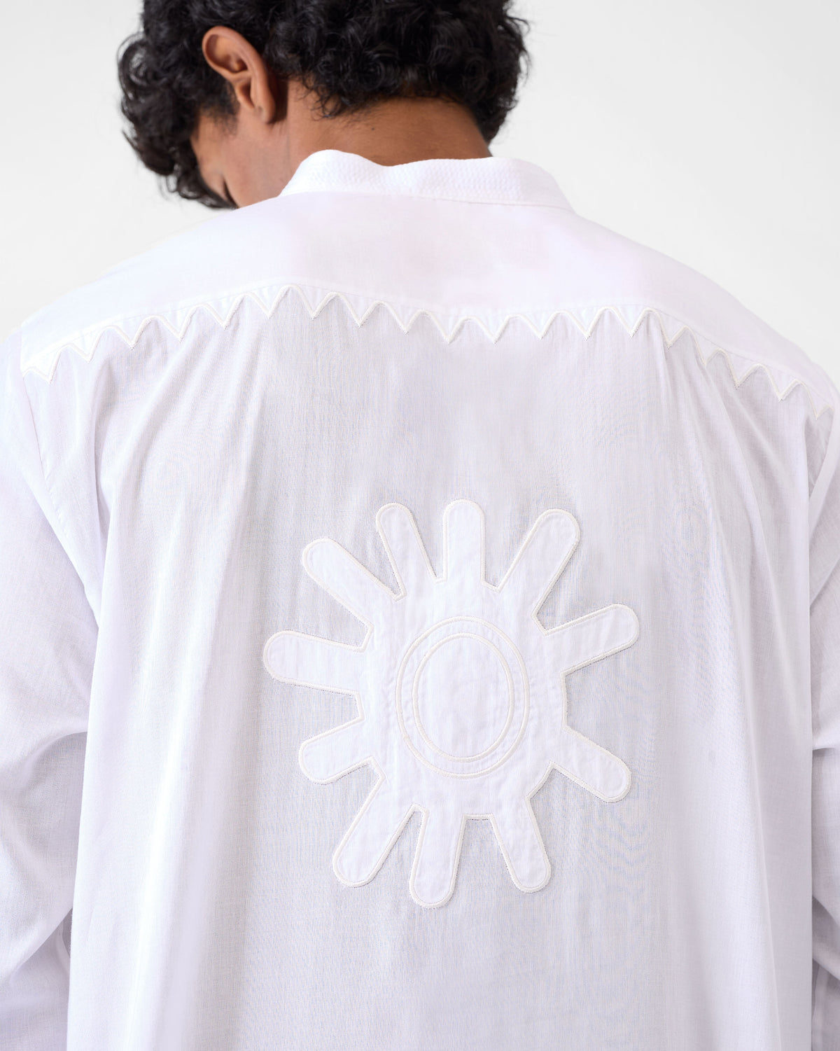 Close-up of a white Neckband Kurta back showing a sun appliqué and zigzag yoke.