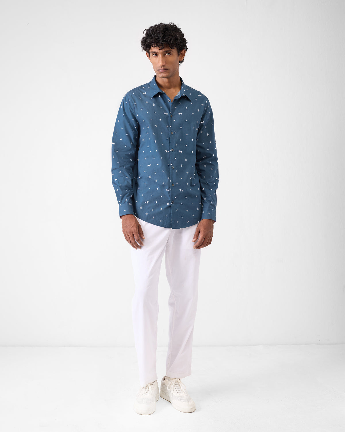 Person wearing a navy Hakuna shirt with an animal Indus print.
